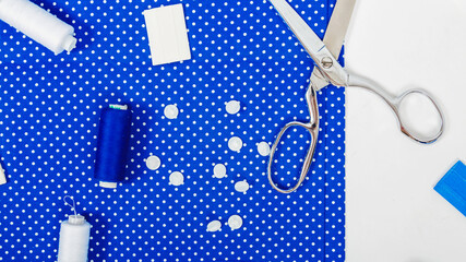 Woman hobby. Set for tailor shop with scissors, threads, sewing tools, blue fabric on white background top view