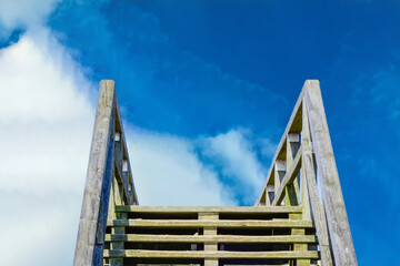 Holztreppe vor blauem Himmel