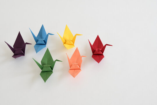 LGBT rainbow colored Origami paper cranes on white background.