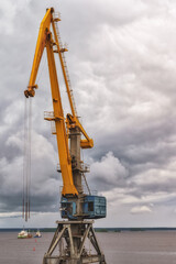 a port crane on the background of a cloudy sky.