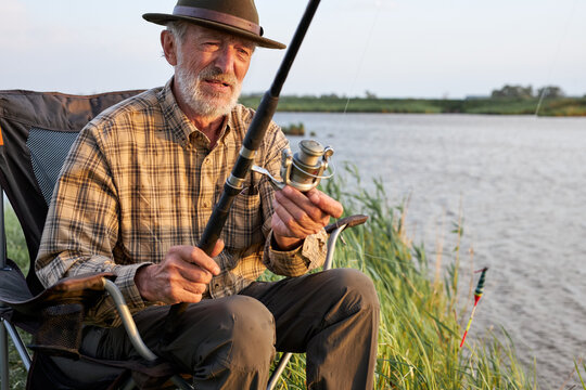 Senior Man Fishing. Fishing On The Lake. Fish On Hook. Master Baiter. Gone Fishing. Summer Vacation. Gray-bearded Man Catching Fish. Retirement Fishery, Alone Outdoors In Nature