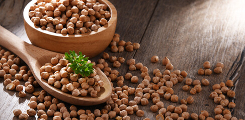 Bowl and spoon of chickpeas on wooden table