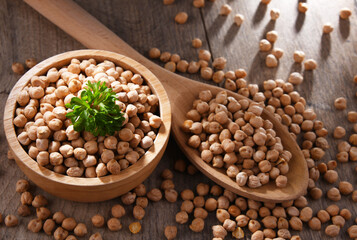 Bowl and spoon of chickpeas on wooden table