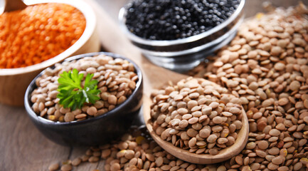Composition with three sorts of lentils on wooden table