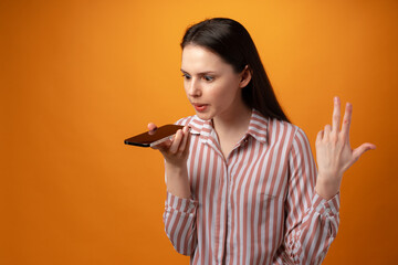 Stressed frustrated young woman holding smartphone, recieved bad news, yellow background
