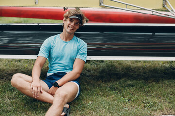 Sportsman single scull man rower portrait sitting relaxing after training competition boat regatta....