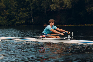 Sportsman single scull man rower rowing at river competition boat regatta. Olympic games sport