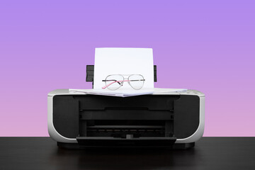 Home laser printer on desk against purple background