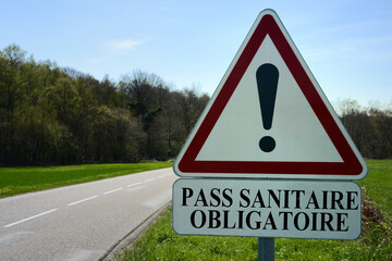 Concept de panneau de circulation routière indiquant en français pass sanitaire obligatoire