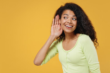 Curious nosy african american young brunette woman 20s wears green shirt try to hear you overhear...