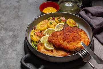 German schnitzel and potato salad with green beans, red onion,  mustard, lemons.