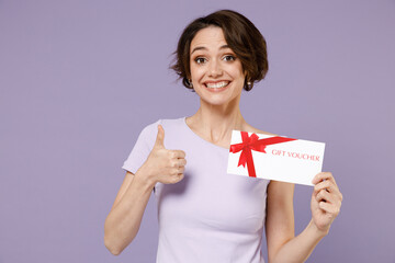 Young smiling fun woman 20s with bob haircut wearing white t-shirt hold gift certificate coupon...