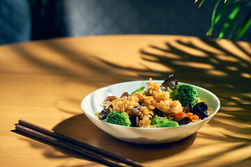 Fried wok noodles with seafood, shiitake mushrooms and vegetables in sweet and sour sauce. Chinese cuisine.