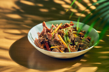 Fried lamb with cumin and vegetables in a white plate. Chinese cuisine.
