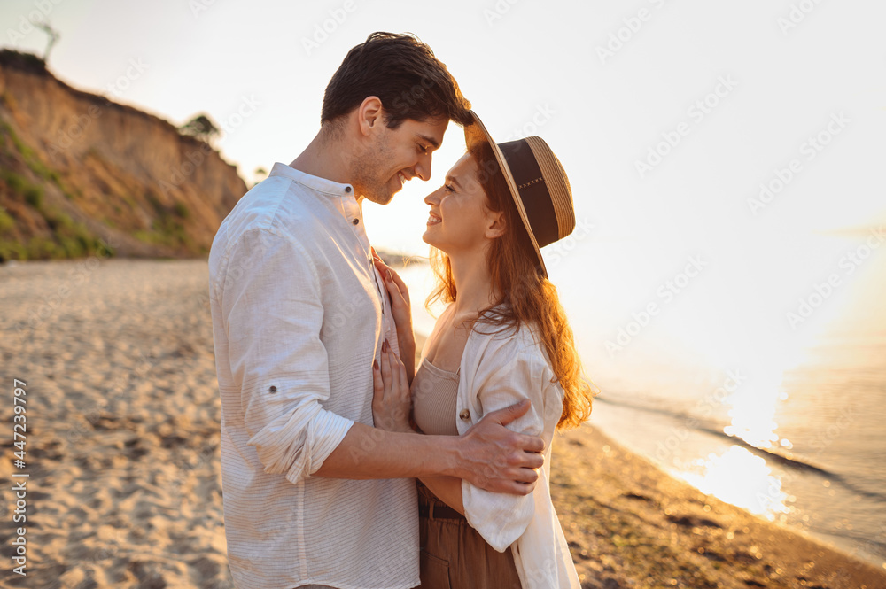 Wall mural side view happy romantic young couple two friends family man woman 20s in white clothes hug going to