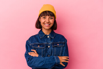 Young mixed race woman isolated on pink background who feels confident, crossing arms with determination.