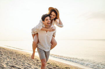 Young excited couple two friends family man woman in casual clothes boyfriend give piggyback ride...