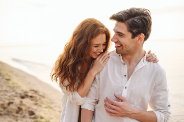 Obraz premium Happy fun young couple two friends family man woman in casual clothes hug girlfriend put head on boyfriend shoulder at sunrise over sea beach ocean outdoor exotic seaside in summer day sunset evening.