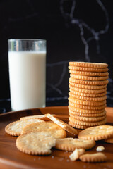 Crackers and milk for snack time on black background