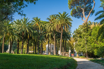 Fototapeta na wymiar Beautiful European green park in Villa Torlonia in Rome, Italy with pathways, trees and lawns.