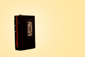 Retro vintage portable cassette player walkman on a vintage yellow background with copy space and room for text with a left side composition