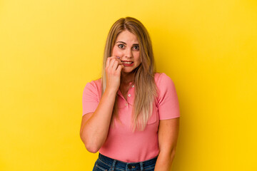 Young russian woman isolated on yellow background biting fingernails, nervous and very anxious.