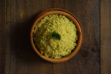 a bowl of  yellow rice on a wooden table 