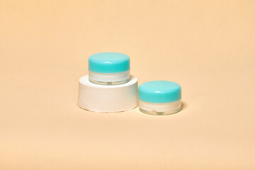 Cosmetics container on the pastel background. Earth colors, zero waste containers. Mockup concept. Minimal boxes and geometric podium. Scene with geometrical forms. 