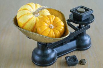 Two small pumpkins on a retro scales