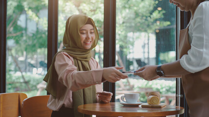 Upwardly mobile Asian Muslim business entrepreneur SME start up group of young man and women, discussing sale and marketing analysis, Asian Muslim SME teamwork e-commerce concept