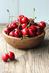 Red cherries in a wooden plate on the table