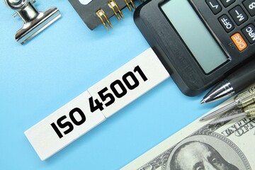 calculator, paper clip, paper money, arrow with word iso 45001