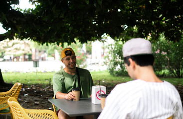 two male friends have a conversation and talk to each other, outdoors