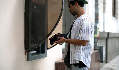 close up person using ATM to take some cash money from bank card