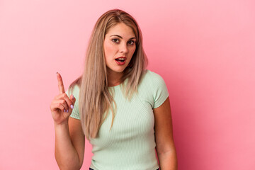 Young russian woman isolated on pink background having an idea, inspiration concept.