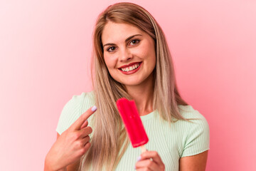 Young russian woman holding an ice cream isolated on pink background