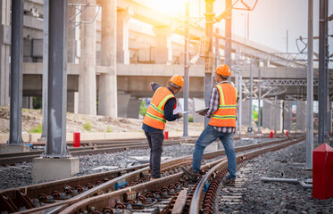 Engineer under inspection and checking construction process railway switch and checking work on railroad station .Engineer wearing safety uniform and safety helmet in work.