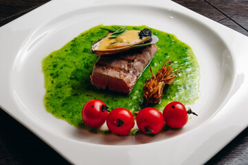 Grilled tuna steak with vegetable with cherry tomatoes, mussel and sauce
