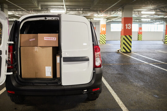 Background image of delivery van or moving van filled with boxes at parking lot, copy space