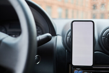 Close up background image of smartphone with blank screen at car dashboard, copy space