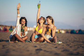 Group of young women friends drinking together on the beach