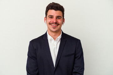 Young business caucasian man wearing wireless headphones isolated on white background happy, smiling and cheerful.