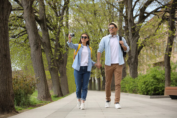 Obraz premium Happy couple of tourists with camera on city street