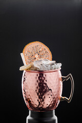 Author's cocktail in a copper glass isolated on a black background. Close-up. Space for text. High quality photo