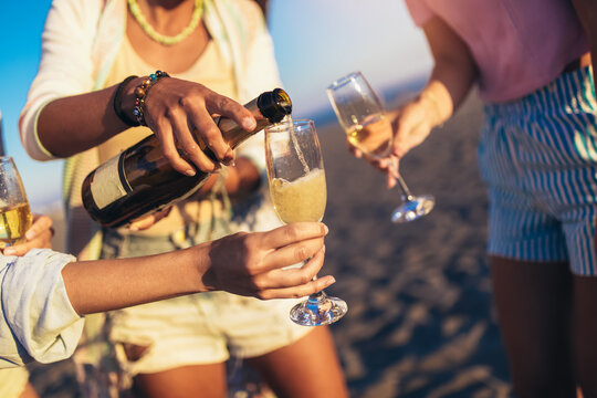 Happy Young Women Drinking Champagne At Bachelorette Party On The Beach