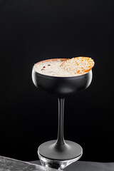 Beautiful cocktail in black frosted glass isolated on black background. Close-up. Space for text. High quality photo
