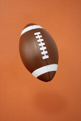 american football on orange background. sport and competition. copy space. 