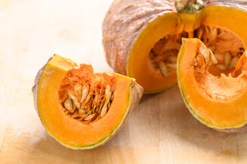 Close up of cutting organic pumpkin on wooden background