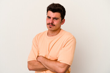 Young caucasian man isolated on white background suspicious, uncertain, examining you.