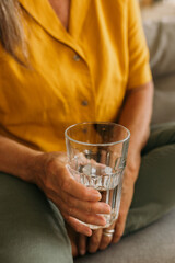 Female person holding glass with cooling water. Sip of water on hot summer day, relaxation with...